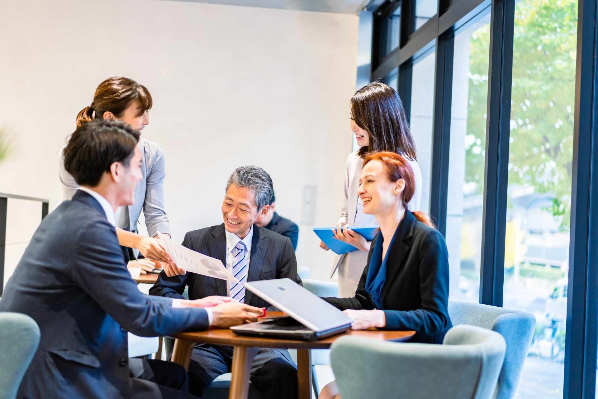 複数人で資料を見ている画像